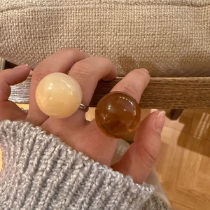 Detail of chunky resin dome rings in cream and amber brown on a silver band