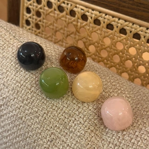 Detailed view of colorful translucent dome stud earrings in five different resin finishes