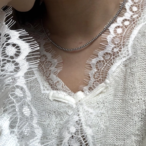 Minimalistische zilveren kralenketting voor dames getoond gedragen op de hals