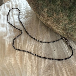 Detailweergave van dunne zwarte kralenketting van 2mm met zilveren sluiting