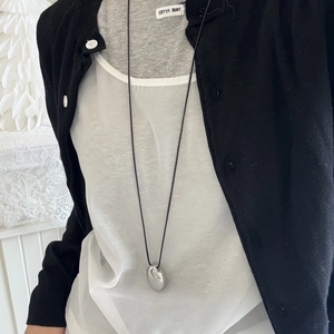 Polished silver bean pendant on a long black cord necklace for minimalist styling