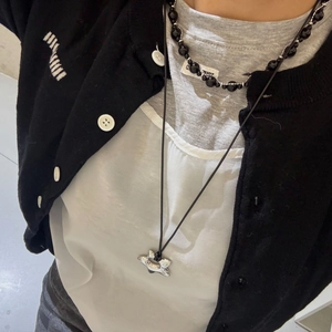 Detail of layered necklace featuring black beaded choker and silver star pendant