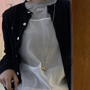 Collar largo dorado con un colgante de bolso minimalista con detalles fruncidos