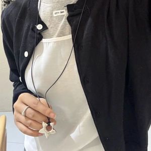 Minimalist silver hollow star pendant on black cord necklace shown on model