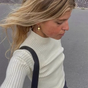 Gros plan de boucles d'oreilles goutte dorées sur un mannequin pour un style mode élégant