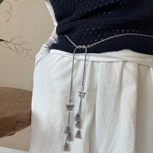 Detail of silver bohemian waist chain featuring butterfly pendant and ethnic bells