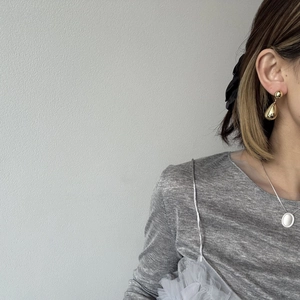 Boucles d'oreilles dorées en goutte d'eau et collier assorti sur un mannequin