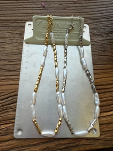 Detail of baroque pearl and organic textured metal link necklace in gold and silver