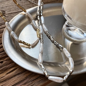Baroque pearl necklace with irregular metallic tubes on a steel tray for women
