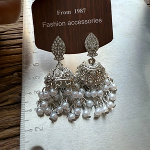 Detail of vintage silver Jhumka earrings with leaf pattern, diamonds and pearls on tag