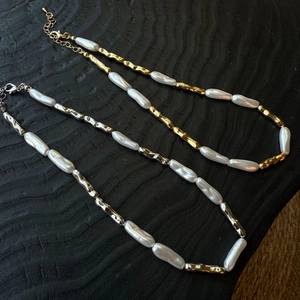 Detailed macro of irregular baroque pearl necklaces with textured metal links
