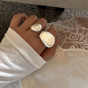 Detail of silver-tone brushed metal ring with unique organic pebble-shaped design
