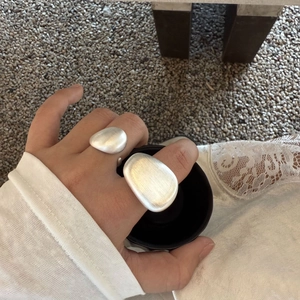 Detail view of silver matte rings with brushed finish and smooth pebble-like design