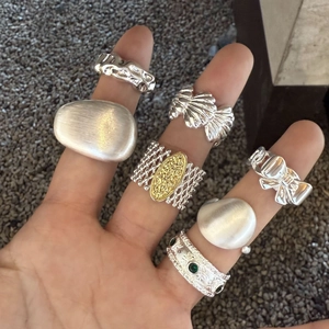 Close-up of Italian brushed silver rings with intricate lattice and ribbon textures