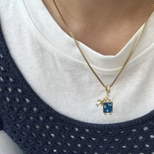 Gouden titanium halsketting met 3D-vliegtuigje en blauwe emaille reiskoffer hangers