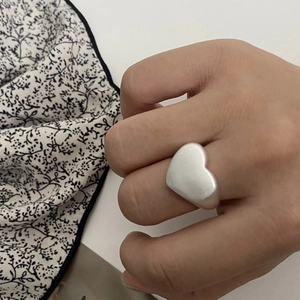 Minimalist silver heart ring with brushed matte finish shown on index finger