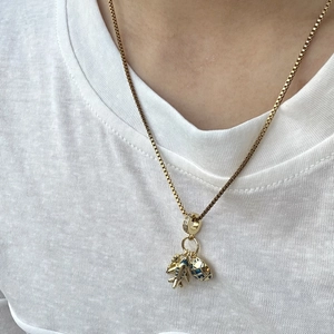 Detail van een reisketting met gouden vliegtuig en blauwe wereldbol bij een model