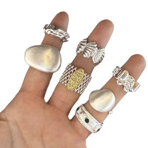 Italian brushed metal rings collection featuring shell, bow, and vintage geometric patterns