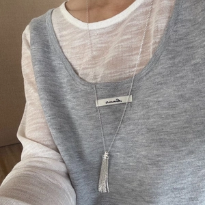 Modern silver-plated tassel lariat necklace for women over a grey knit sweater