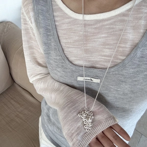 Detailed view of silver grape cluster pendant on a fine snake chain long necklace