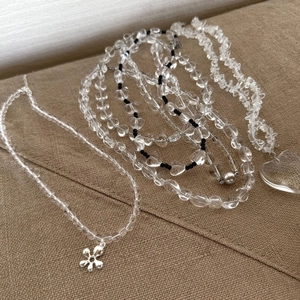 Macro-opname van kristallen kralenketting met zilveren bloem en transparant hart