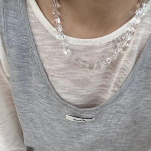 Ketting met onregelmatige kristallen hartvormige hanger en kralen op sleutelbeen