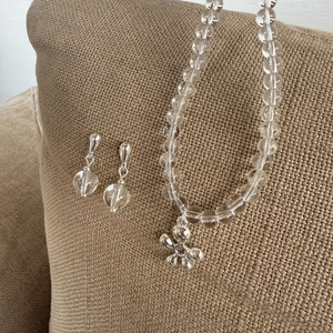 Minimalistische kralen sieradenset met zilveren bloemhangers en heldere kralen