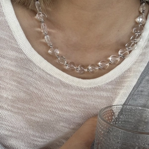 Detailopname van hartvormige kristallen kralenketting met zilveren kralen op een model