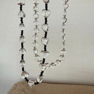 Detailopname van de kralenketting met transparante hartjes en zwarte ronde kralen