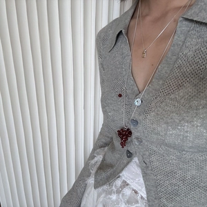 Long layered crystal grape pendant necklace with silver chain on knitted cardigan