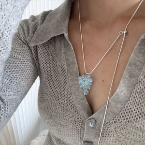 Detail of adjustable silver long necklace with light blue crystal grape cluster pendant