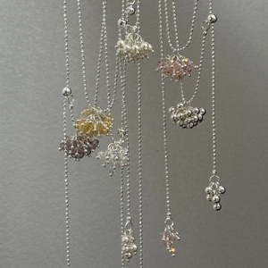 Detail of silver beaded necklace with clusters of pearls and colorful crystals
