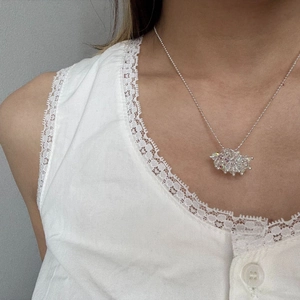 Detailed close-up of a silver beaded necklace featuring a floral crystal cluster pendant