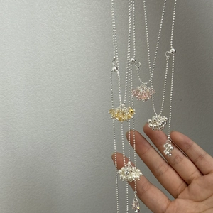 Detail of silver ball chain necklaces with colorful crystal beads and pearls