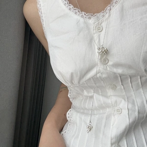 Silver bead Y-necklace with cluster pendant on model featuring elegant white lace blouse
