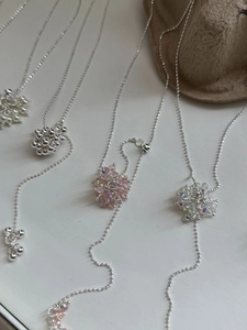 Detail view of handmade flower cluster necklaces with silver beads and crystal accents