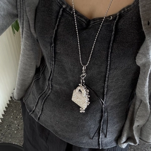 Silver bead necklace with crystal encrusted mini handbag pendant and black cord details