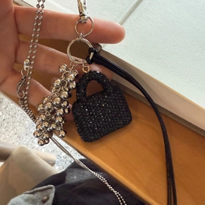 Detail of a black rhinestone mini handbag pendant with silver metal bead chains