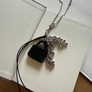 Macro shot of exquisite black beaded bottle pendant with silver chain and lobster clasp