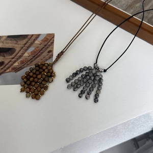 Detail of natural stone beaded pendant necklaces with vintage woven and leather cords