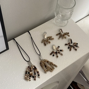 Macro shot of boho jewelry set with natural stone beads and silver tassel accents