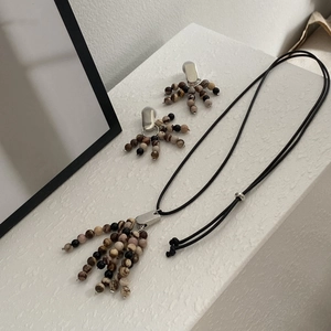 Detail view of handmade natural stone beaded necklace and matching tassel earrings set