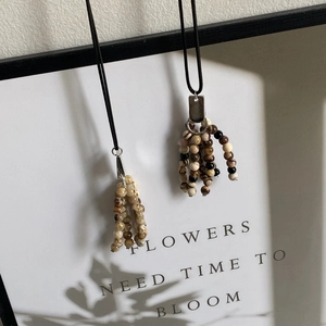 Detail of natural stone beaded tassel necklaces with silver clasps on display board