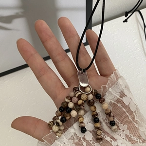 Macro view of multi-strand natural stone beaded necklace with vintage metal ring link