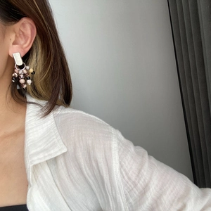 Detail of silver drop earrings with natural stone beads on a female model