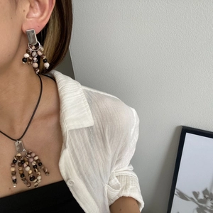 Detail of beaded tassel necklace and earrings set featuring natural earth-toned stones