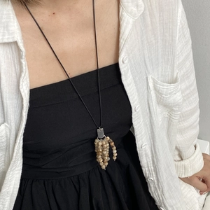 Long beaded tassel pendant necklace featuring natural stone beads on a black cord