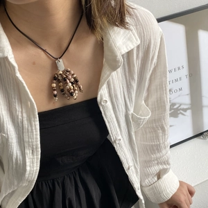 Detail of bohemian long pendant necklace featuring multi-color natural stone bead tassels