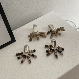 Detailed macro view of bohemian style silver earrings featuring natural stone bead fans
