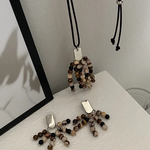 Detail of bohemian jewelry set featuring natural stone beads and silver stainless earrings